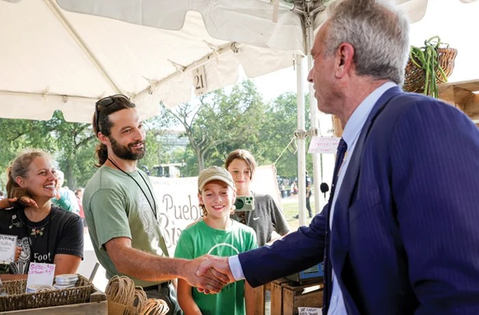Secretary of Health & Human Services Robert F. Kennedy Jr. greets a market vendor, Aug. 4, 2025. ( (Bryan Dozier/NurPhoto/AP)