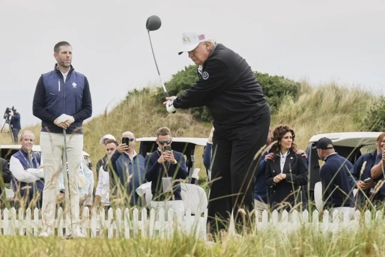 President Donald Trump tees off as Eric Trump, left, stands by during the opening ceremony for the Trump International Golf Links golf course, near Aberdeen, Scotland, Tuesday, July 29, 2025. (AP Photo/Jacquelyn Martin)