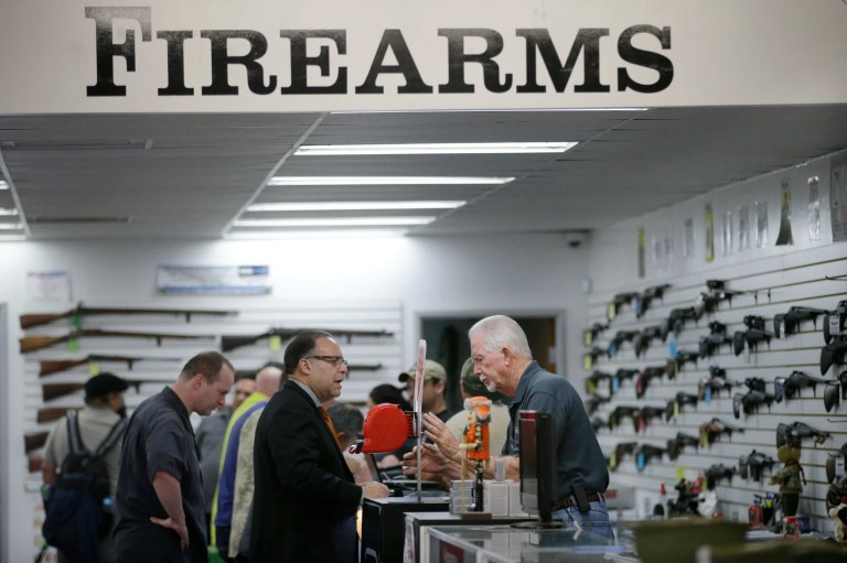 In this Dec. 9, 2015, file photo, sales associate Mike Conway, right, shows Paul Angulo guns at Bullseye Sport gun shop in Riverside, California. Lawmakers passed a package of bills to strengthen California’s already tough gun laws. Voters reinforced them by passing even more measures.