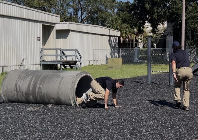 An Immigration and Customs Enforcement instructor demonstrates how to navigate the obstacle course at the Federal Law Enforcement Training Center in Glynco, Georgia on Aug. 21, 2025.