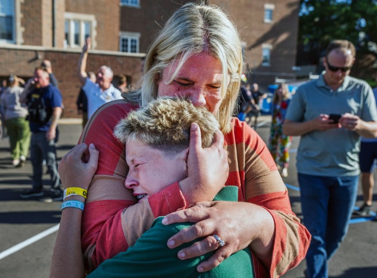 A parent hugs her son during an active shooter situation at the Annunciation Church in Minneapolis, Minn., Wednesday, Aug. 27, 2025. (Richard Tsong-Taatarii/Star Tribune via AP)