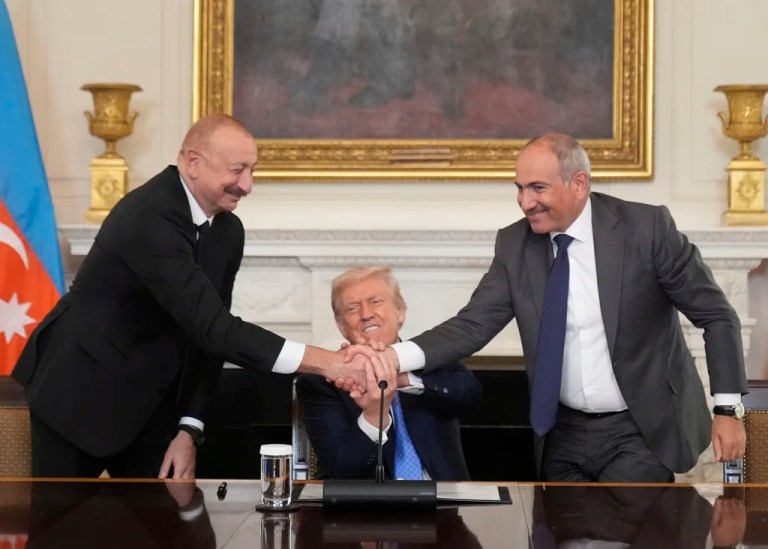 President Donald Trump, center, shakes hands with Armenian Prime Minister Nikol Pashinyan, right, and Azerbaijan President Ilham Aliyev during a trilateral signing ceremony in the State Dining Room of the White House, Friday, Aug. 8, 2025, in Washington. (AP Photo/Mark Schiefelbein)