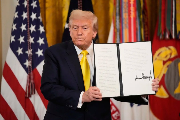 President Donald Trump holds up a signed proclamation declaring National Purple Heart Day in the East Room of the White House, Thursday, Aug. 7, 2025, in Washington.