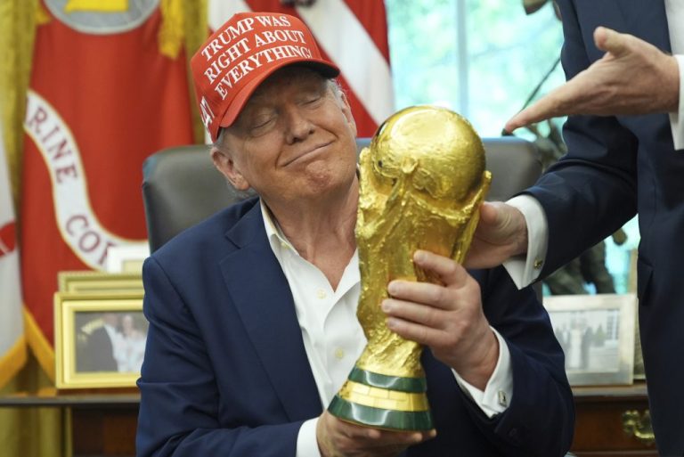 President Donald Trump holds the FIFA World Cup Winners Trophy during an announcement in the Oval Office of the White House, Friday, Aug. 22, 2025, in Washington. (AP Photo/Jacquelyn Martin)
