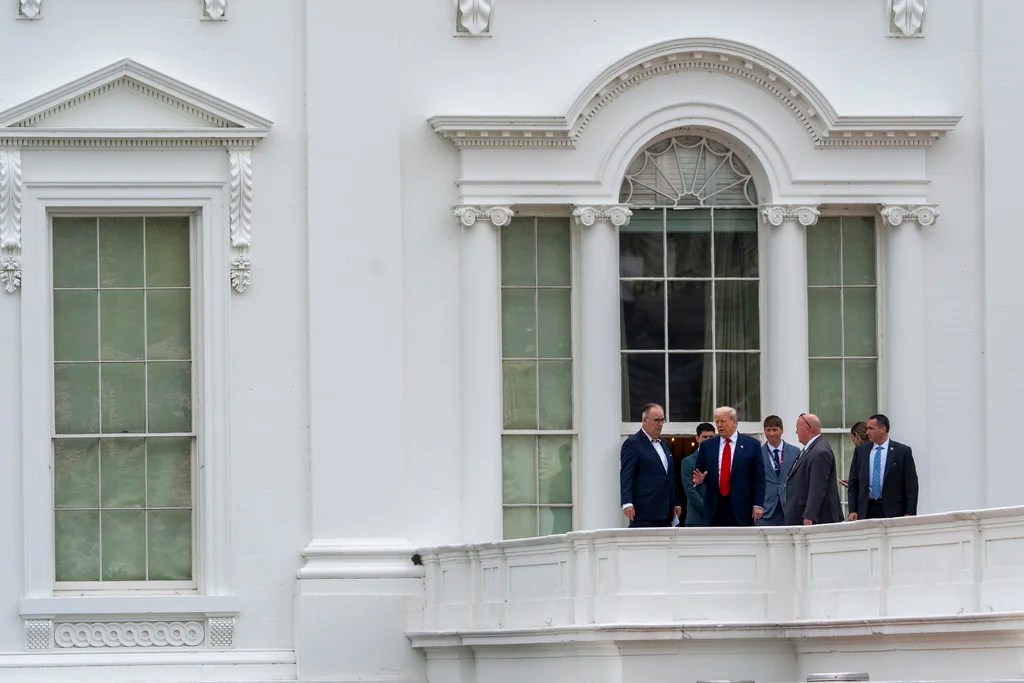 President Donald Trump, second from left, with architect James McCrery, left, surveys the grounds from the roof above the Colonnade that goes to the West Wing of the White House, Tuesday, Aug. 5, 2025, in Washington.