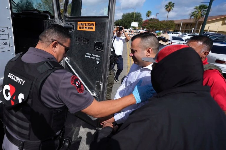 Federal agents escort a man to a transport bus after he was detained following an appearance at immigration court, Monday, July 28, 2025, in San Antonio. (AP Photo/Eric Gay)