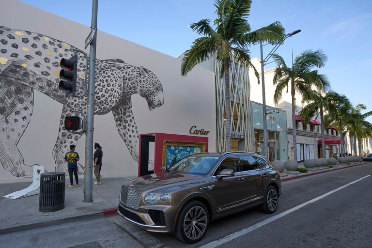 A car sits outside shops on Rodeo Drive in Beverly Hills, California.