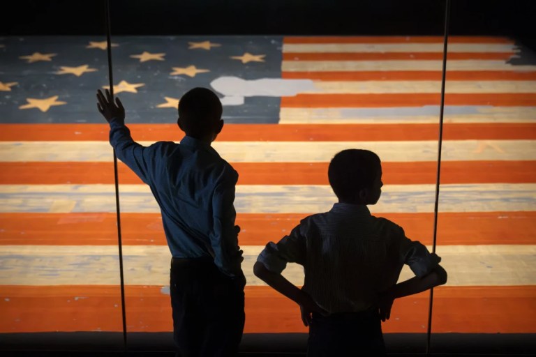 Children look at the Star Spangled Banner, the flag that inspired the lyrics of the American national anthem, at the Smithsonian's National Museum of American History, Tuesday, June 10, 2025, in Washington. (AP Photo/Mark Schiefelbein)