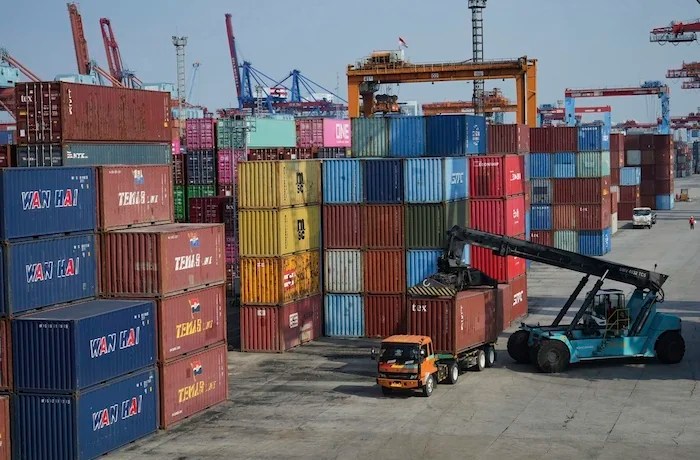 A crane unloads a shipping container from a truck at IPC Container Terminal at Tanjung Priok Port in Jakarta, Indonesia, Wednesday, Aug. 6, 2025.