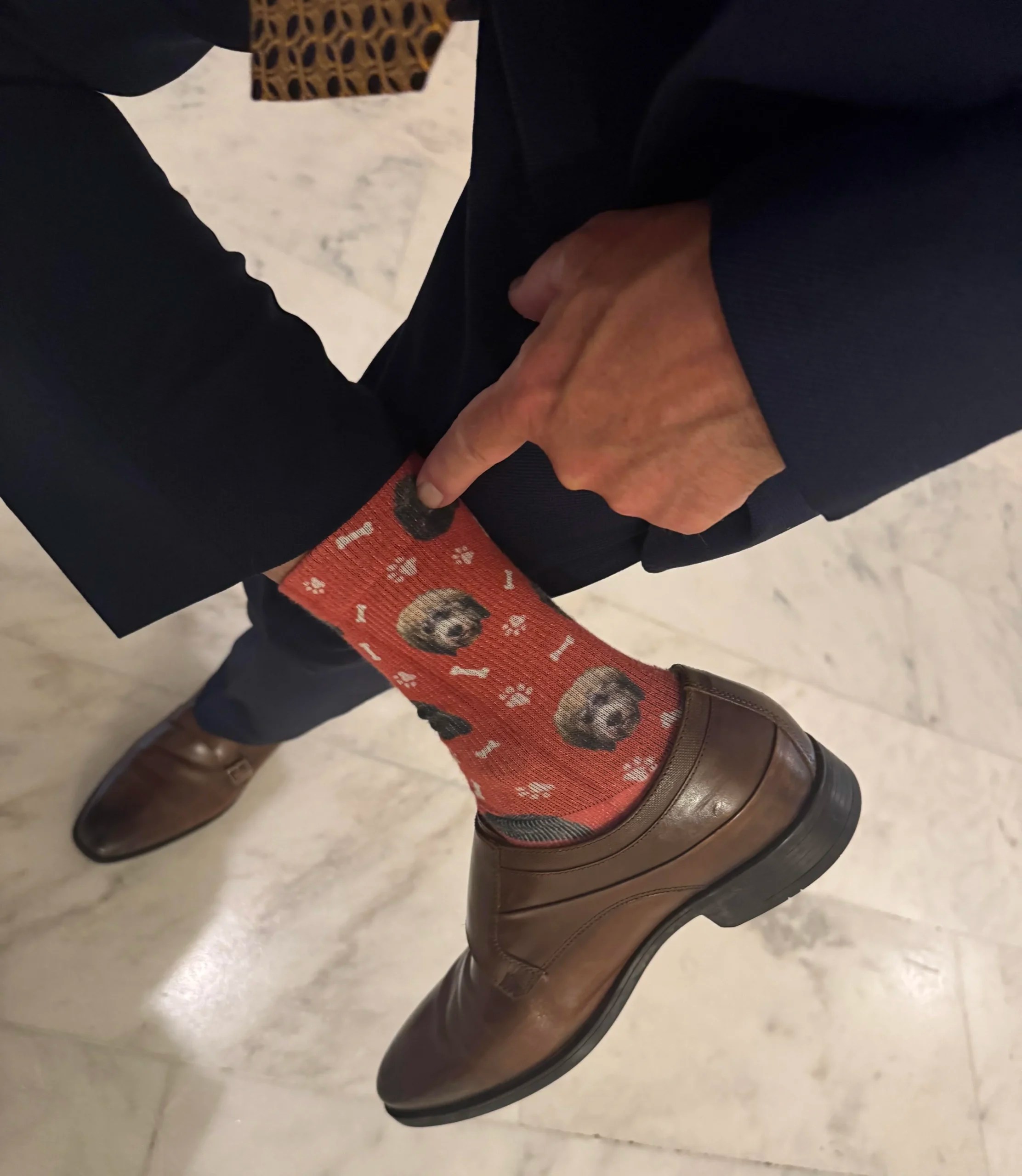 Sen. Thom Tillis (R-NC) shows off dress socks printed with the faces of his dogs, Mitch and Theo on July 23, 2025.