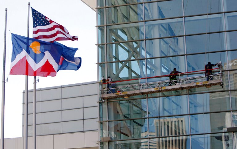The Colorado state flag flutters before the Colorado Convention Center in downtown Denver.