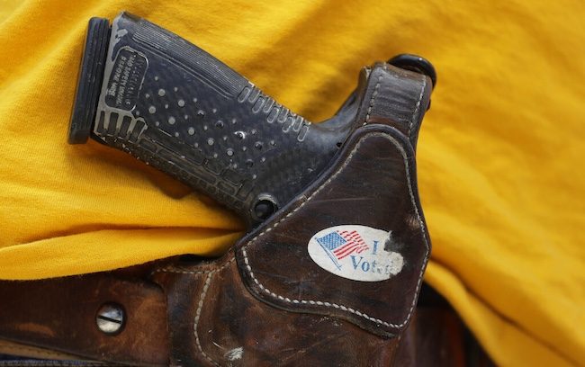 In this April 14, 2018 file photo, a man wears an unloaded pistol during a pro gun-rights rally in Austin, Texas.