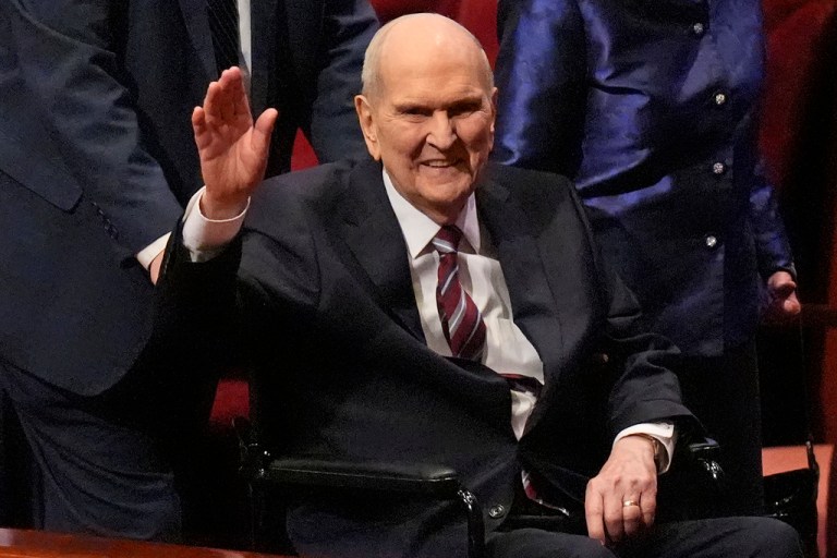 President Russel M. Nelson waves while seated in a wheelchair