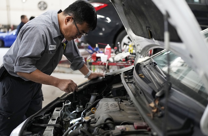 Auto mechanic Willie Chung works on a vehicle at the Express Auto Service Inc., in Chicago, Thursday, Sept. 19, 2024