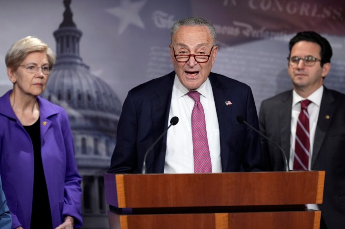 Senate Minority Leader Chuck Schumer, D-N.Y., center, flanked by Sen. Elizabeth Warren, D-Mass., left, and Sen. Brian Schatz, D-Hawaii, speaks about the Department of Government Efficiency, or DOGE, during a news conference at the Capitol in Washington, Monday, Feb. 3, 2025