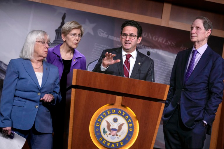 Sen. Brian Schatz, D-Hawaii, speaks as Sen. Patty Murray, D-Wash., from left, Sen. Elizabeth Warren, D-Mass., and Sen. Ron Wyden, D-Ore., ranking member of the Senate Finance Committee, listen during a news conference at the Capitol in Washington
