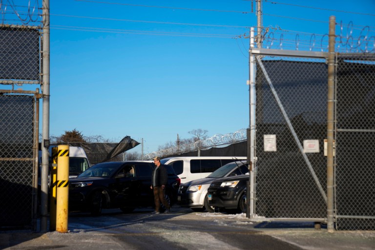 Vehicles are parked behind the gate of an ICE detention center in Broadview, Illinois.