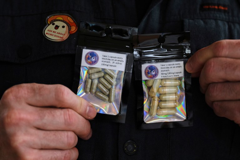 Marine Corps combat veteran Matt Metzger, who grows his own mushrooms for microdosing psilocybin, displays prepared doses in packets.