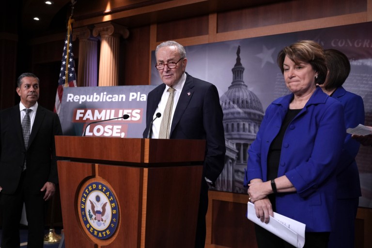 Senate Minority Leader Chuck Schumer, D-N.Y., flanked by Sen. Ben Ray Lujan, D-N.M., left, and Sen. Amy Klobuchar, D-Minn., speaks to reporters at the Capitol, in Washington, Friday, April 4, 2025