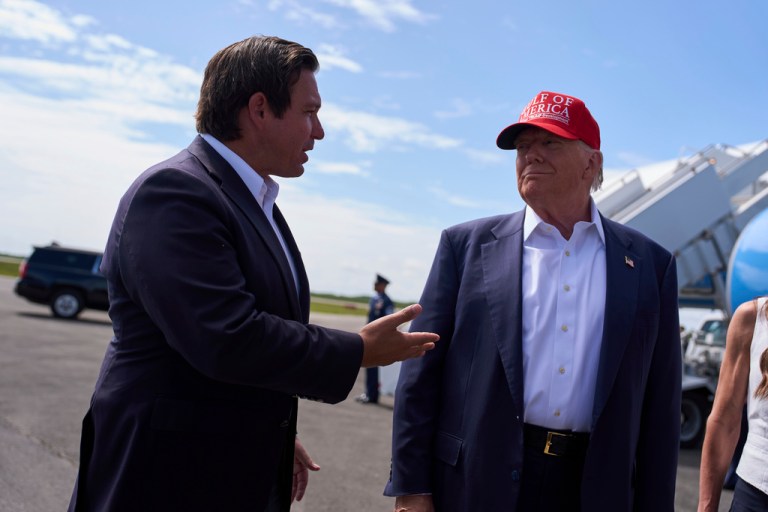 President Donald Trump listens as Gov. Ron DeSantis (R-FL) speaks with reporters.