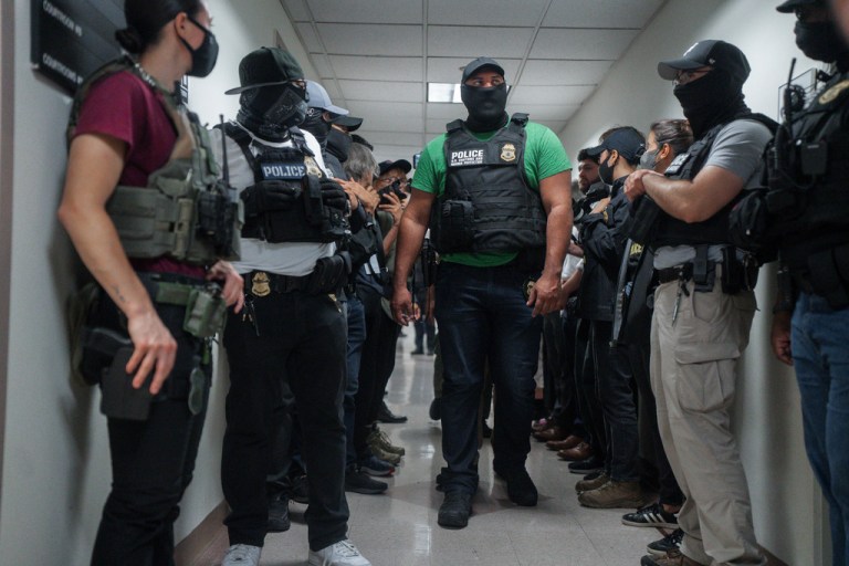 Masked federal agents wait outside an immigration courtroom on Tuesday, July 8, 2025, in New York.