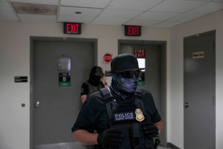 Federal agents stand outside an immigration court.