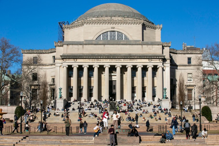Students sit on the front steps of Low Memorial Library on the Columbia University campus.