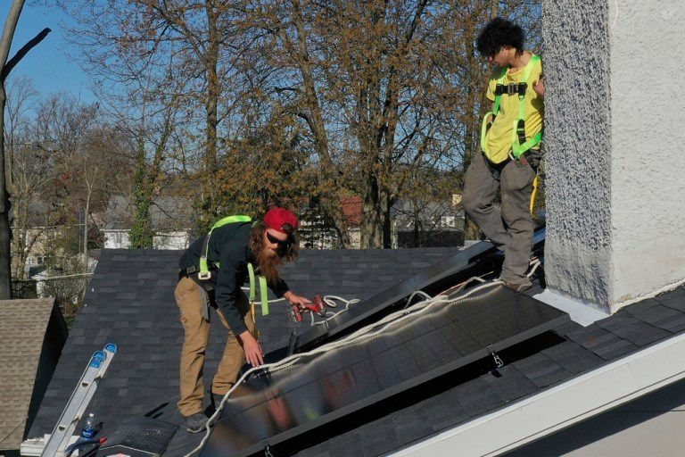 People installing solar panels on a roof of a home