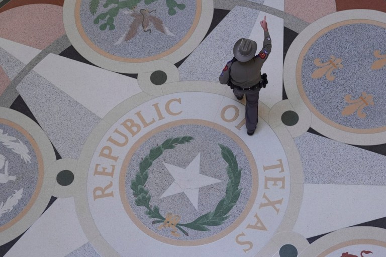 A Texas troopers passes the Texas Seal on the Rotunda of the Texas Capitol before debate on a bill for a redrawn U.S. congressional map during a special session in the Senate Chamber in Austin, Texas.