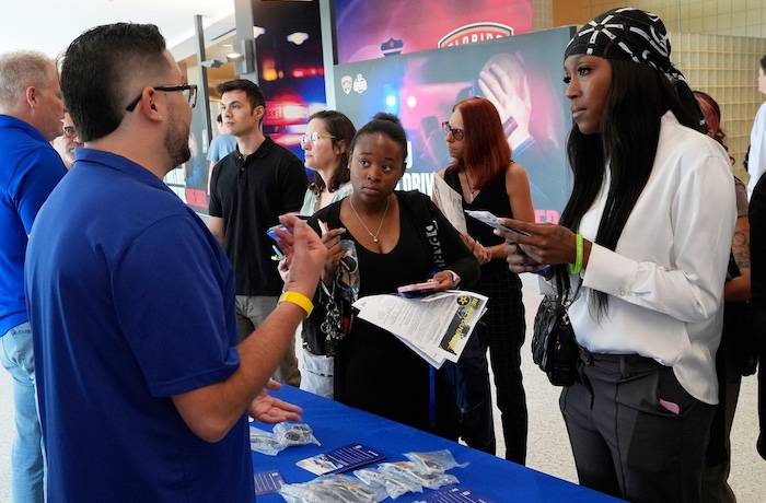 Job seekers listen to Logan Reed, a talent acquisition coordinator for Princess Cruise Line.