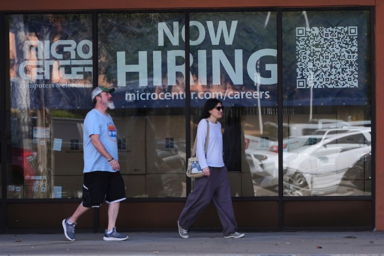 Pedestrians walk by a 
