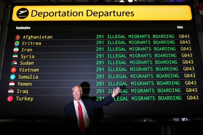 British Reform party leader Nigel Farage poses in front of a mock departures board.