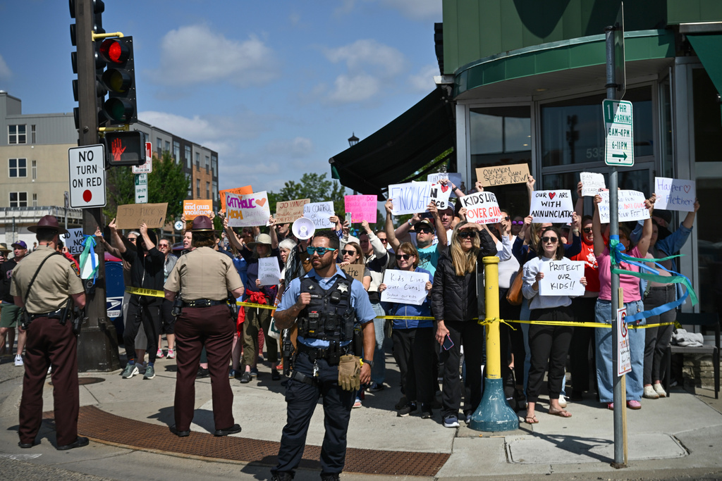 People protest as Vice President JD Vance and his wife, second lady Usha Vance, arrive on Wednesday, Sept. 3, 2025, to pay their respects to victims of the Annunciation Catholic Church shooting in Minneapolis. 