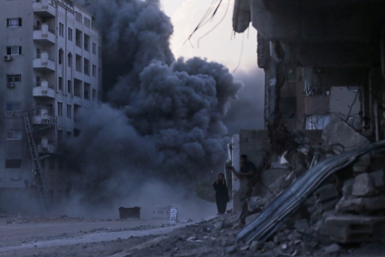 Palestinians take cover during an Israeli strike on a building in Gaza City, Sunday, Sept. 7, 2025, after the Israeli army issued a prior warning.