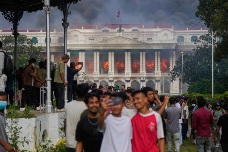 Protesters take selfies and celebrate at the Singha Durbar, the seat of Nepal's government's various ministries and offices, after it was set on fire during a protest against social media ban and corruption.