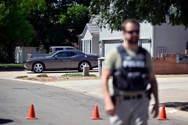 A law enforcement official stands guard outside the family home of Tyler Robinson.