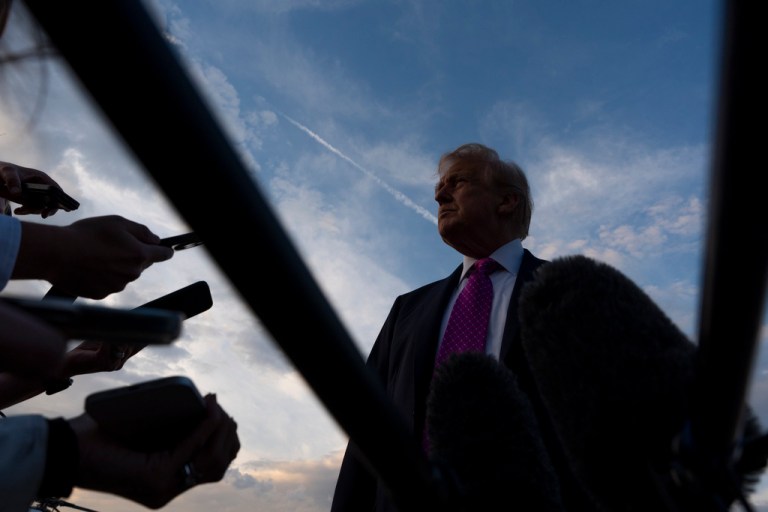 President Donald Trump answers questions from the press on the tarmac in New Jersey.
