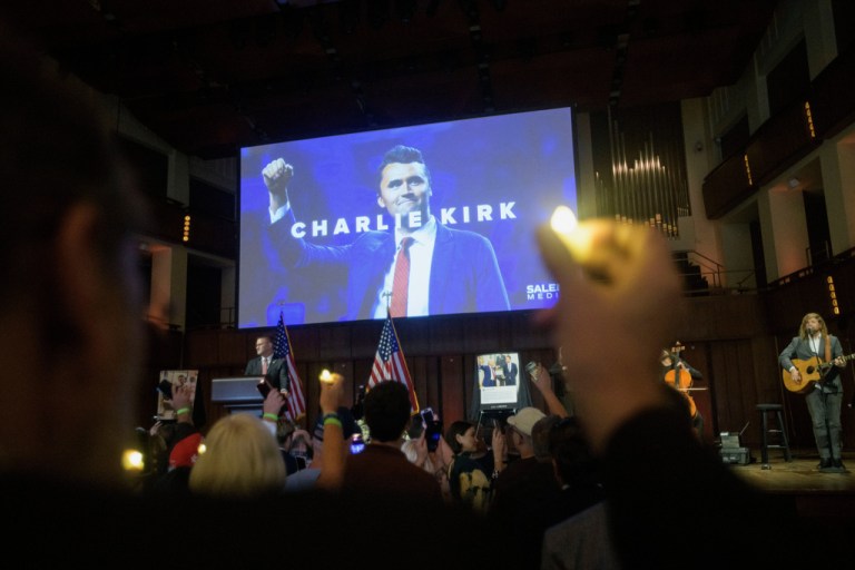 People hold candles and sing during a memorial and prayer vigil for Charlie Kirk.