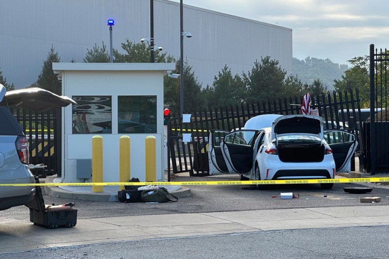 FBI officials inspect a car that rammed into the gate of an FBI building gate in Pittsburgh.