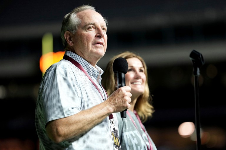 Outgoing Texas A&M University President Mark Welsh holds a microphone.