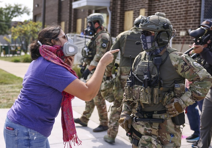 A protester confronts an Immigration and Customs Enforcement officer outside of an ICE facility in Broadview, Friday, Sept. 19, 2025. (Anthony Vazquez/Chicago Sun-Times via AP)