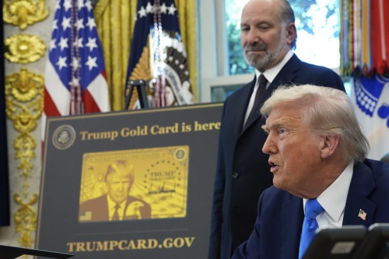 President Donald Trump speaks as Commerce Secretary Howard Lutnick listens.