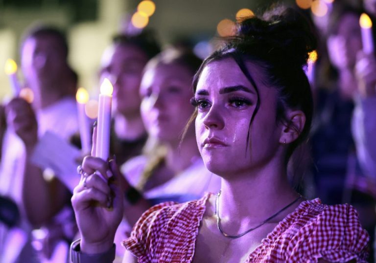 A student holds a candle at a prayer vigil for Charlie Kirk at Utah Valley University.