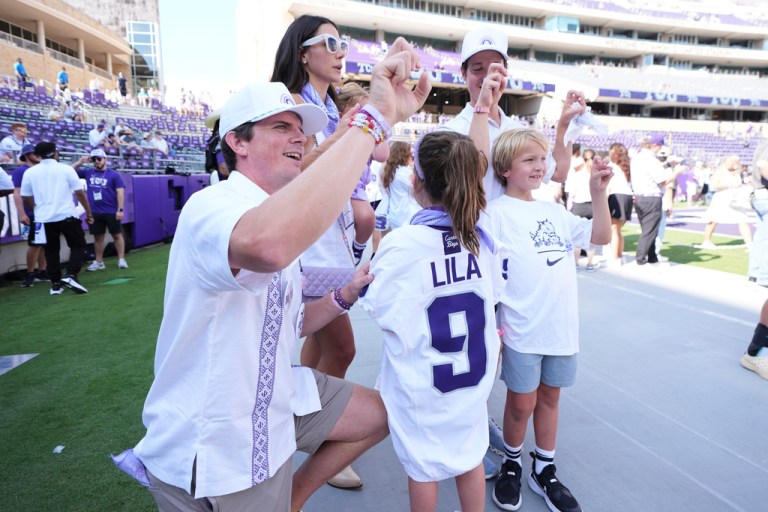 Blake Bonner, left, his wife Caitlin, left rear, standing and their daughter, front, wearing a shirt with her late sisters name stand in the end zone before an NCAA college football game between SMU and TCU, Saturday, Sept. 20, 2025, in Fort Worth, Texas. (AP Photo/Tony Gutierrez)