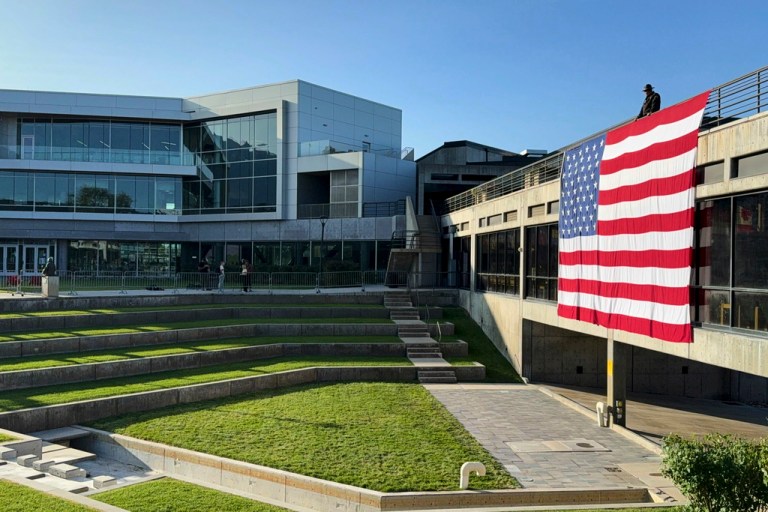 A national flag hangs over the site where conservative activist Charlie Kirk was shot and killed at Utah Valley University.