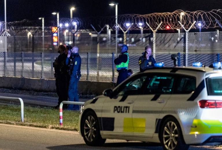 Danish police stand outside Copenhagen Airport after mysterious drones were spotted.