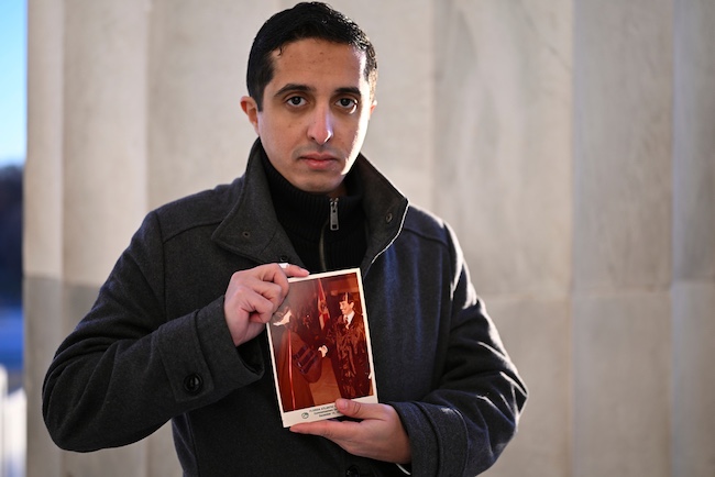 Ibrahim Almadi holds a photo of his father, Saad Almadi.