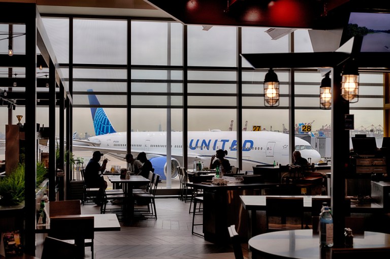 A United Airlines plane is parked on the tarmac outside a restaurant at Newark Liberty International Airport.