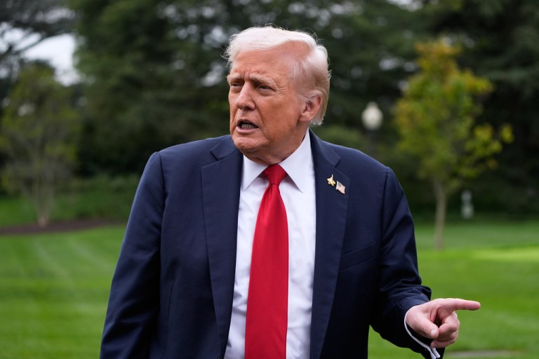 President Donald Trump speaks with reporters outside.