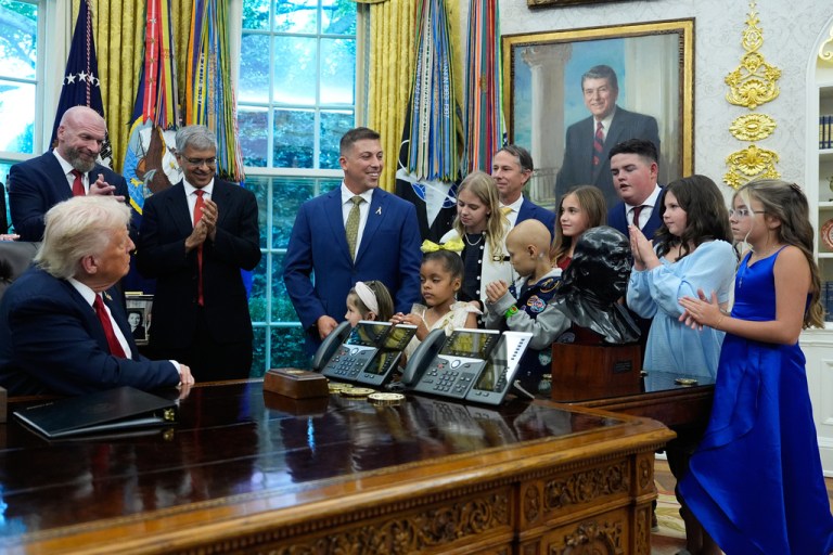 President Donald Trump listens to children who have survived cancer as he speaks in the Oval Office of the White House before signing an executive order regarding childhood cancer and the use of AI, Tuesday, Sept. 30, 2025, in Washington. (AP Photo/Alex Brandon)